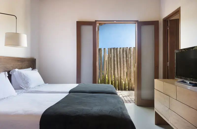 Suíte com duas camas e porta para o jardim