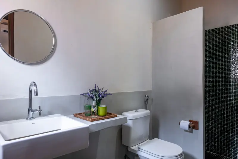 Banheiro de suíte com espelho redondo