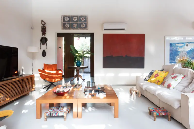 Sala de estar com sofá, poltronas e mesa de centro de madeira