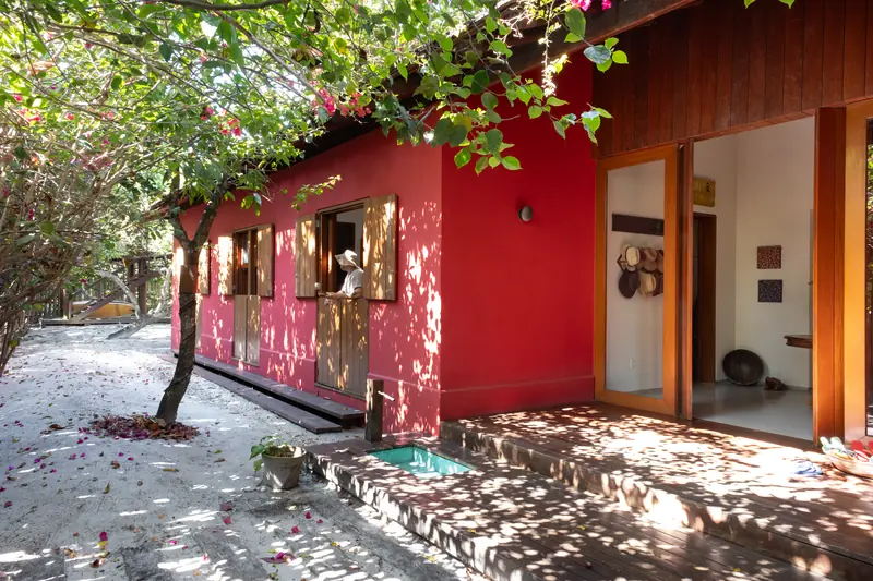 Ala vermelha da casa entre as árvores do jardim