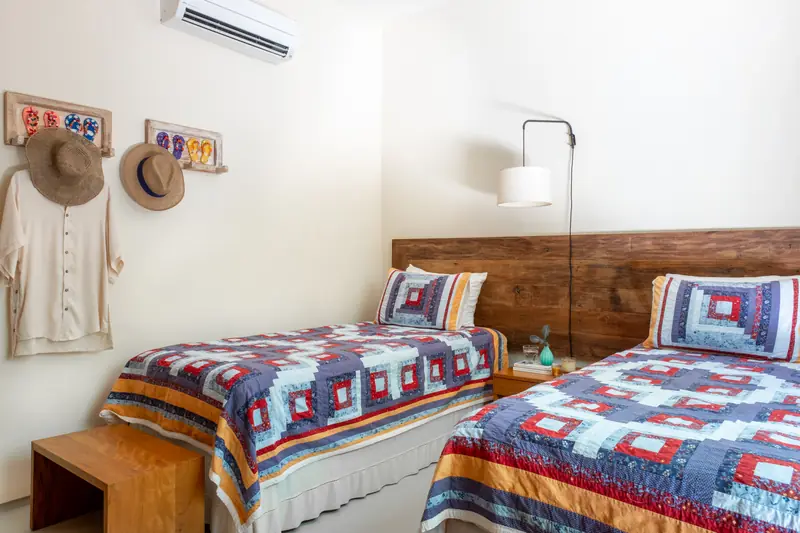 Suíte com duas camas de solteiro e colchas coloridas