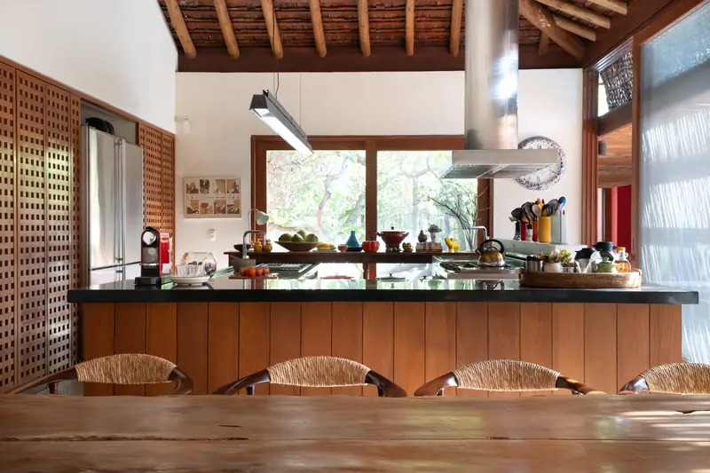 Cozinha com bancada, coifa de inox e bancos