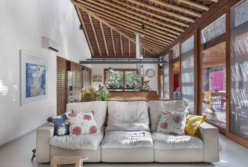 Sala de estar com sofá branco e teto de madeira