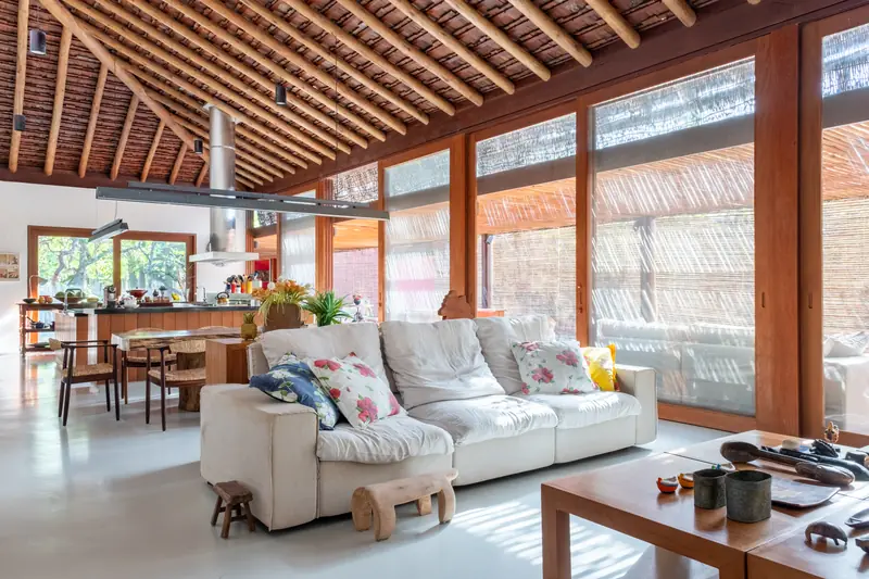 Sala de estar com sofás e janelas para o jardim