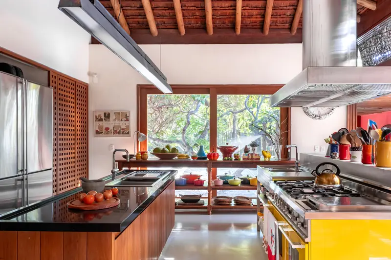 Cozinha com fogão, coifa de inox e bancada escura
