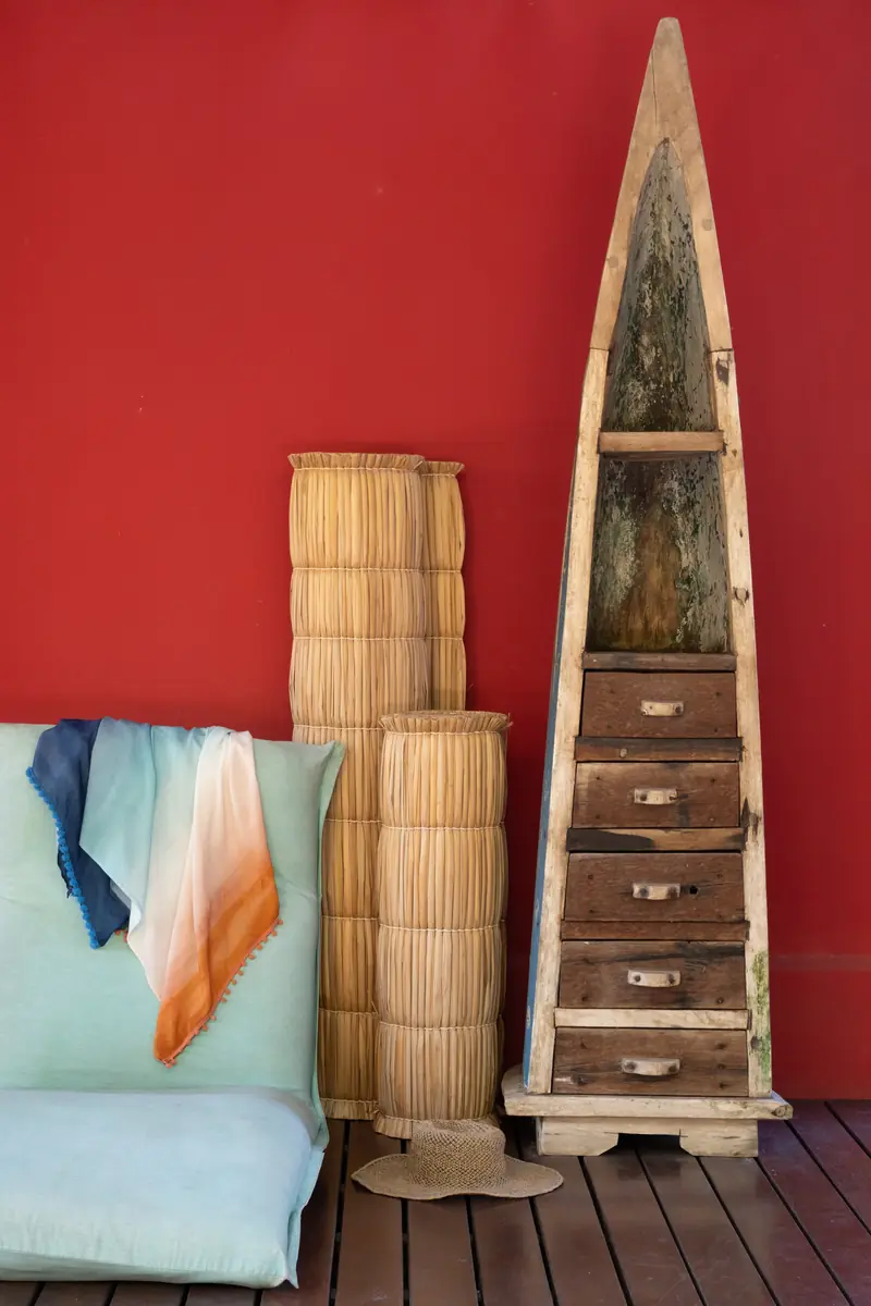 Canto da varanda com parede vermelha e peças decorativas
