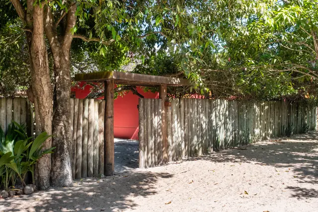 Portão de entrada de madeira com cerca de troncos